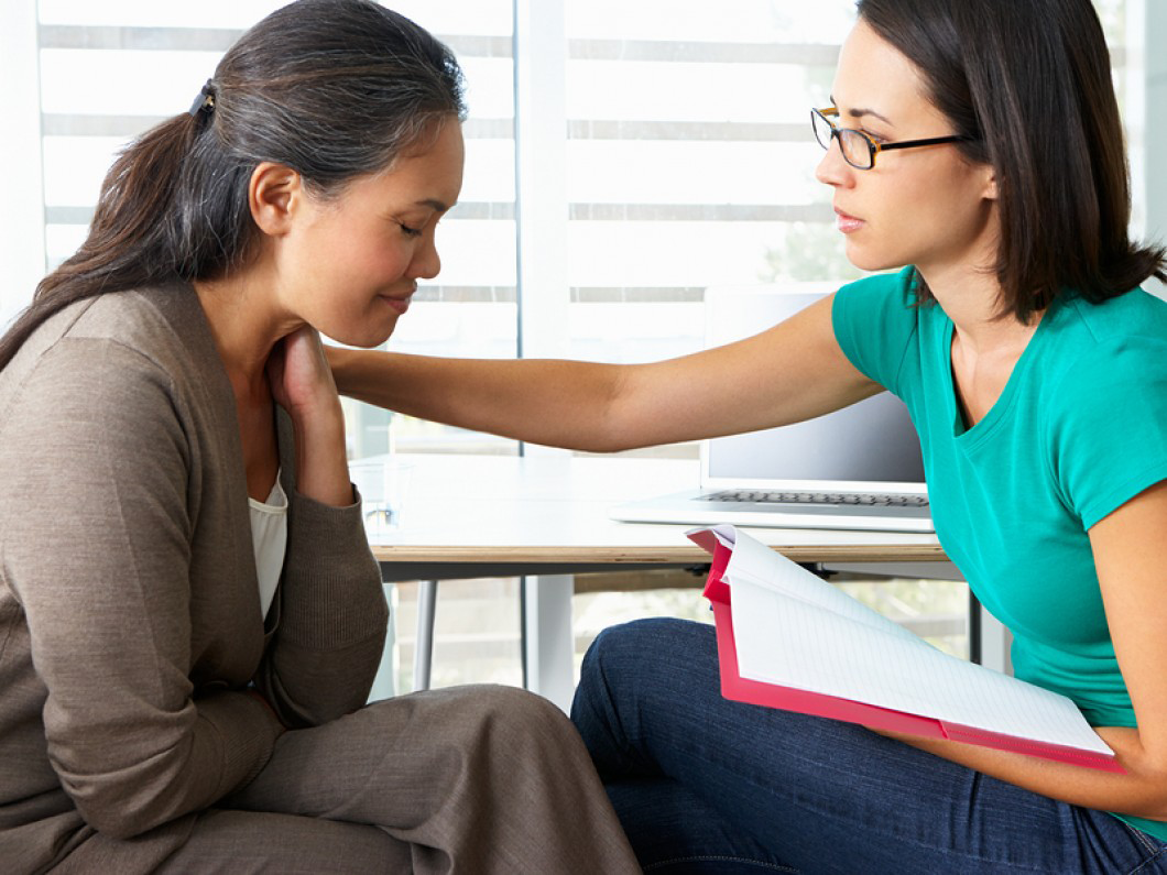 Counseling Session with Therapist touching woman's shoulder
